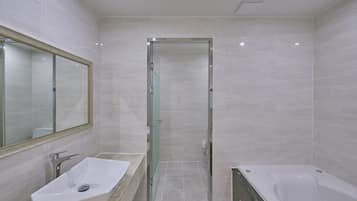A modern bathroom with a glass-enclosed shower, a white sink, and a bathtub.