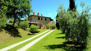 A stone house with a paved driveway leading to the entrance. - Scenic Farmhouse with Pool (Città Della Pieve)