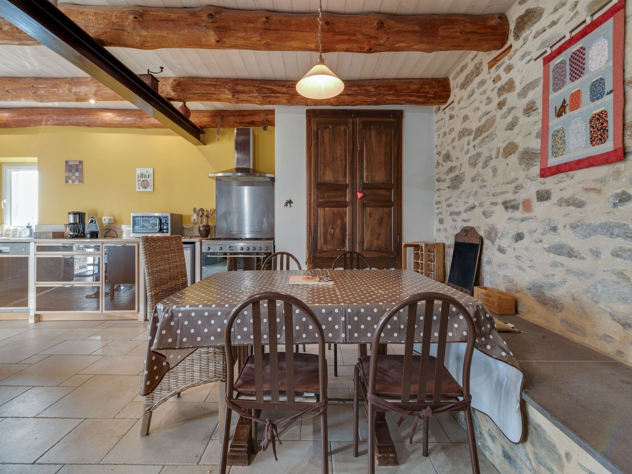 Een gezellige keuken met een houten tafel, stoelen en een fornuis.