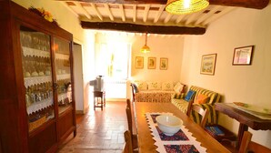 A dining area with a wooden table, chairs, a bowl, and a patterned table runner. - Dreamy Cottage in Trebbio with Pool (Trebbio)