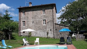 A stone building with a swimming pool, outdoor seating, and a gate. - Dreamy Cottage in Trebbio with Pool (Trebbio)