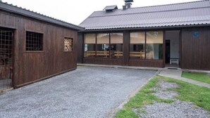 Ein Gebäude mit einem Kieshof, Holzwänden und großen Fenstern.
