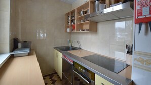 A compact kitchen with a sink, stove, and cabinets. - Spacious Home with Garden (Waimes)