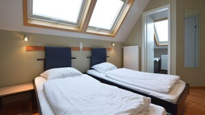 A room with two beds, a skylight, a wooden bench, and a radiator. - Spacious Home with Garden (Waimes)