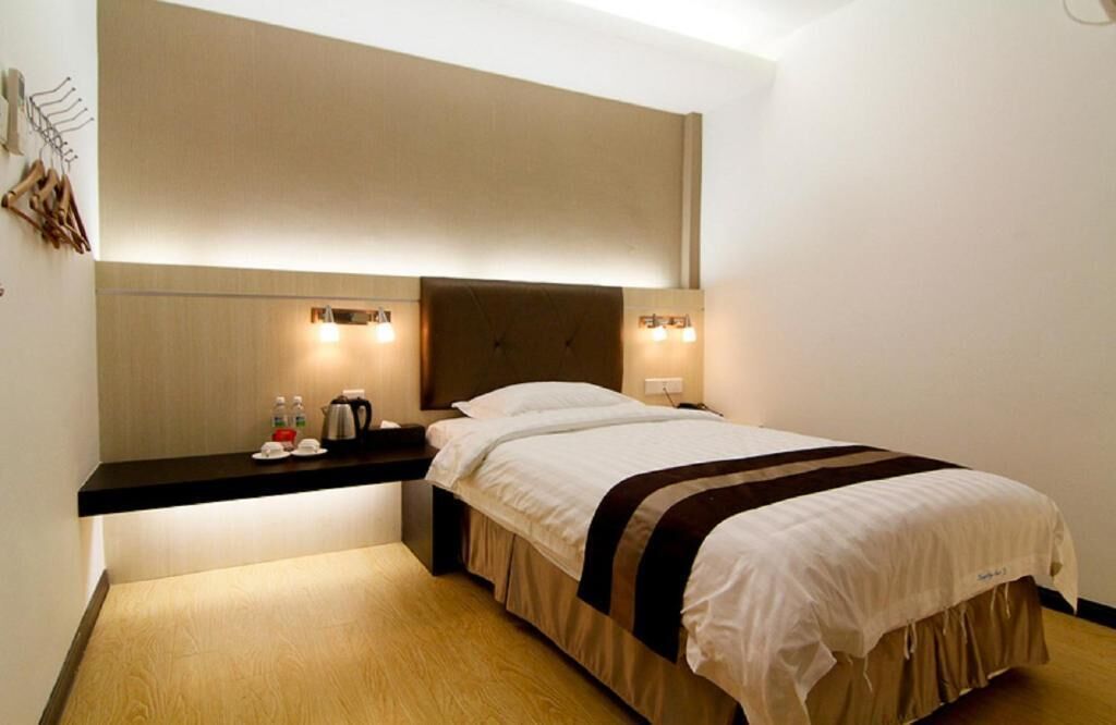 Une chambre d’hôtel équipée d’un lit, d’une table de chevet et d’appliques murales.