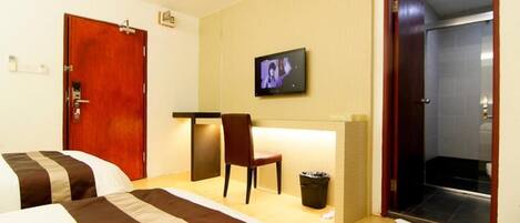 Une chambre d’hôtel avec deux lits, un bureau, une chaise, une télévision et un espace douche.
