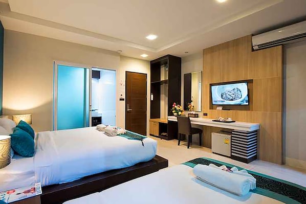 Une chambre d’hôtel équipée d’un lit, d’un bureau, d’une télévision et d’une salle de bain.