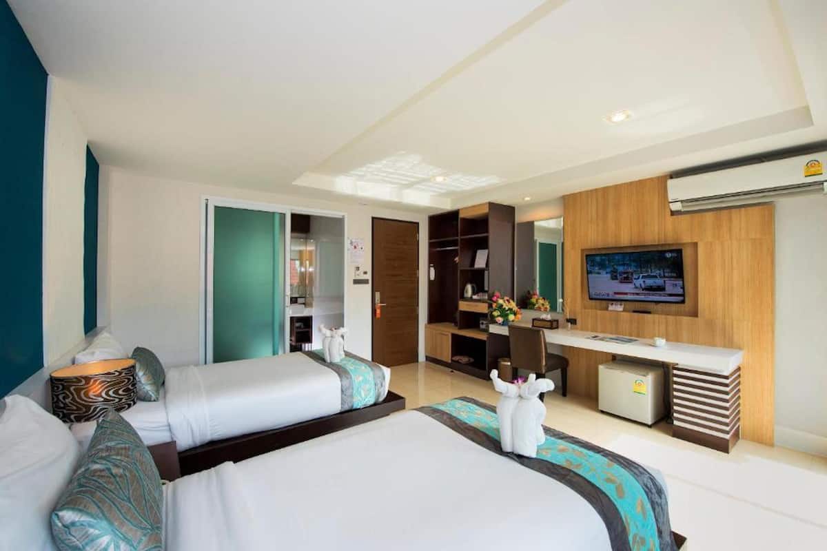 Una habitación de hotel moderna con una cama grande, un escritorio, un televisor y un vestidor.