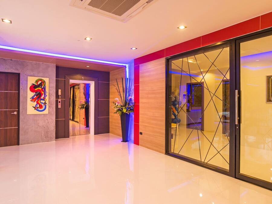 Um hall de hotel moderno com piso reluzente, balcão de recepção e parede divisória de vidro.