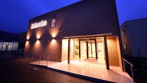 Een hotelentree met een bord waarop "La Jet Inn" staat en een zichtbare ingang.