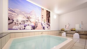 Een moderne badkamer met een groot ligbad, een douchegedeelte en een wastafel aan de muur.