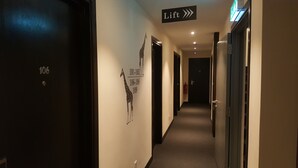A hotel corridor with doors numbered 106, 101-105, 106-108, 109, and a lift direction sign. - 9 Square Hotel - Sri Kembangan (Seri Kembangan)