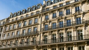 A multi-story building with ornate balconies and large windows.