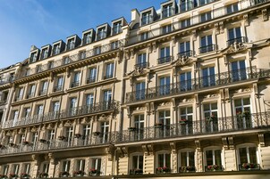 Un immeuble à plusieurs étages, doté de balcons décoratifs et de grandes fenêtres.