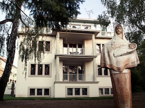 Un bâtiment doté d’un balcon et orné d’une statue à l’avant.