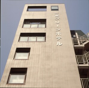 A tall building with a tiled facade and multiple windows.