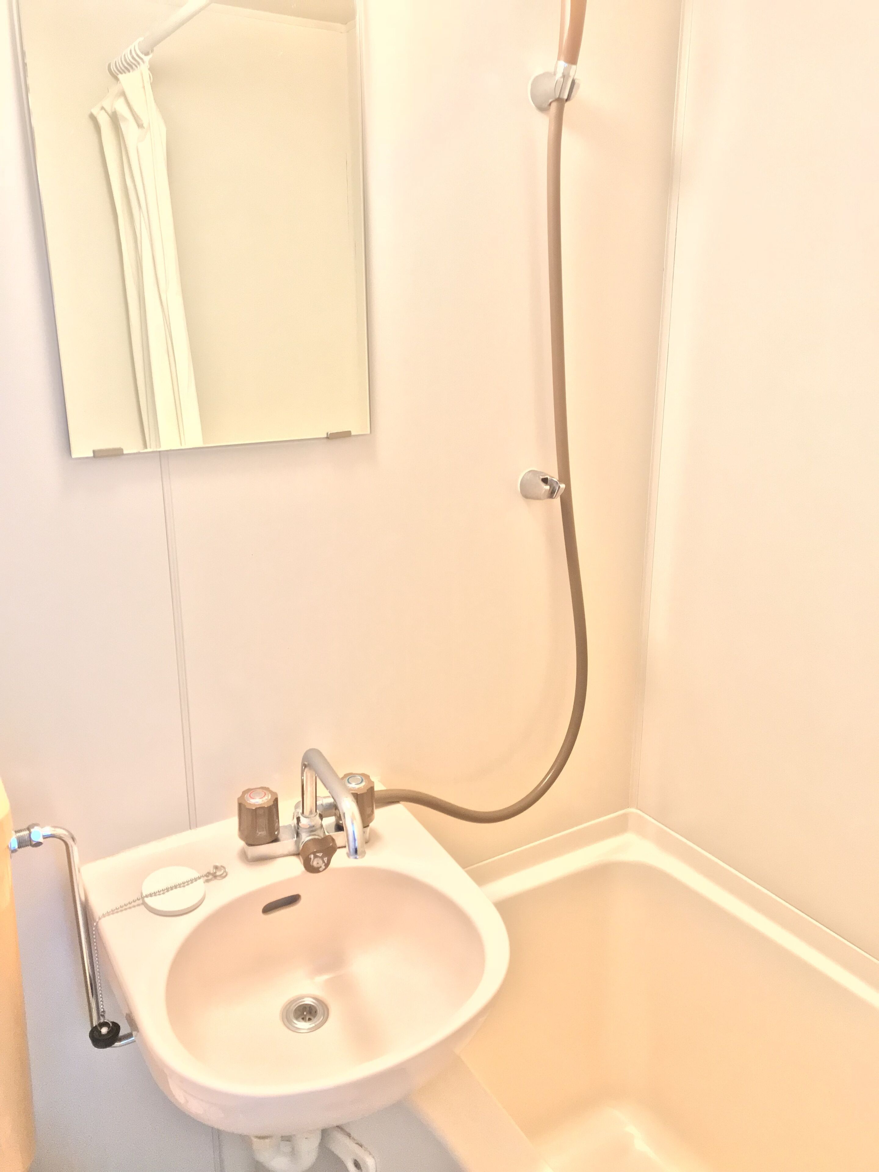 Une salle de bain avec un lavabo, un miroir et une douche.