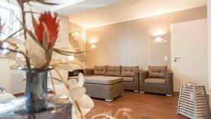 Una sala de estar moderna con un conjunto de sofá, una mesa de centro y un jarrón decorativo con flores.