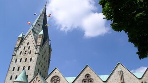 A historic building with a tall tower, arched windows, and a pointed roof. - Aparthotel Paderborn (Paderborn)