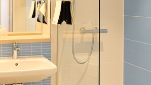 A modern bathroom with a glass-enclosed shower, a sink, and a mirror. - Aparthotel Paderborn (Paderborn)