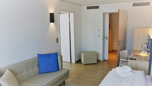 Una habitación de hotel con cama, sofá, escritorio y silla.