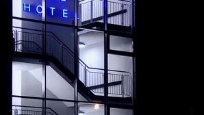 Un hotel de varios pisos con balcones y un cartel que dice "BB ELUE HOTEL".