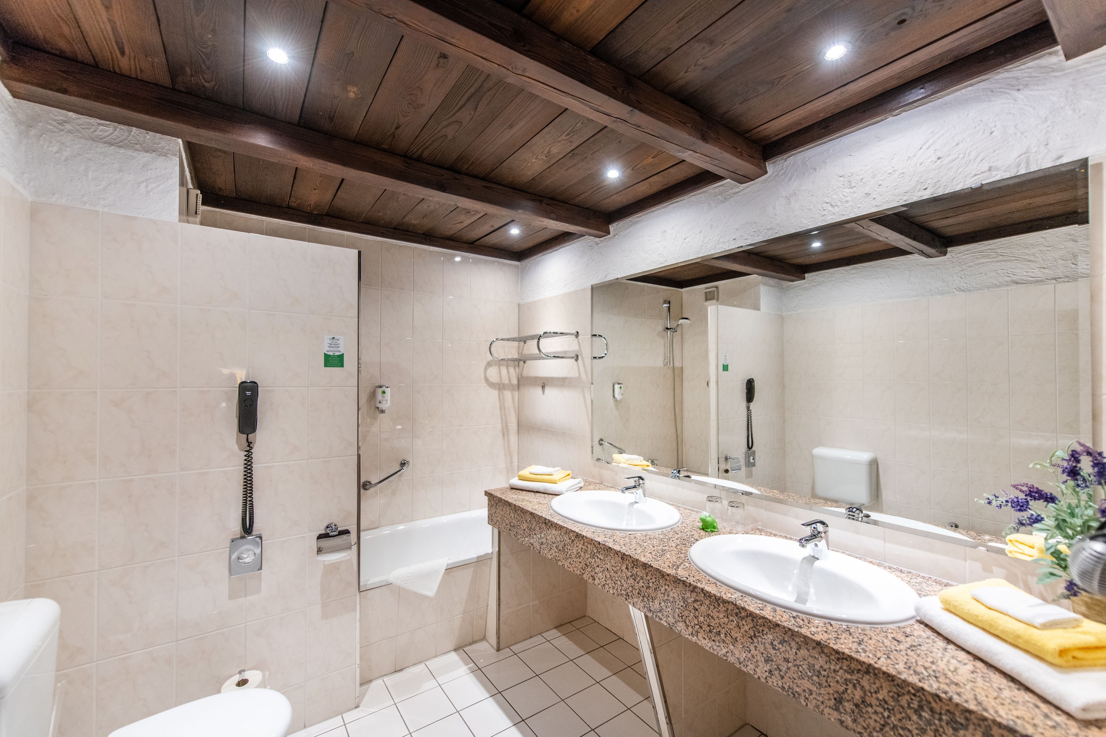 Un baño con dos lavamanos, una bañera y una ducha.