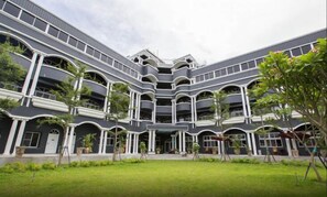 A multi-story building with a central courtyard, surrounded by balconies and potted plants. - Jin Huei Hotel (Luye)