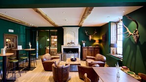 A cozy room with leather sofas, a wooden coffee table, and a fireplace. - Hotel la Malle Poste (Rochefort)