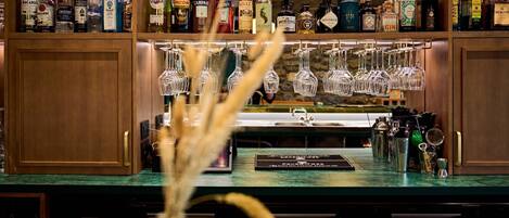 A bar area with shelves of liquor bottles and hanging glasses.