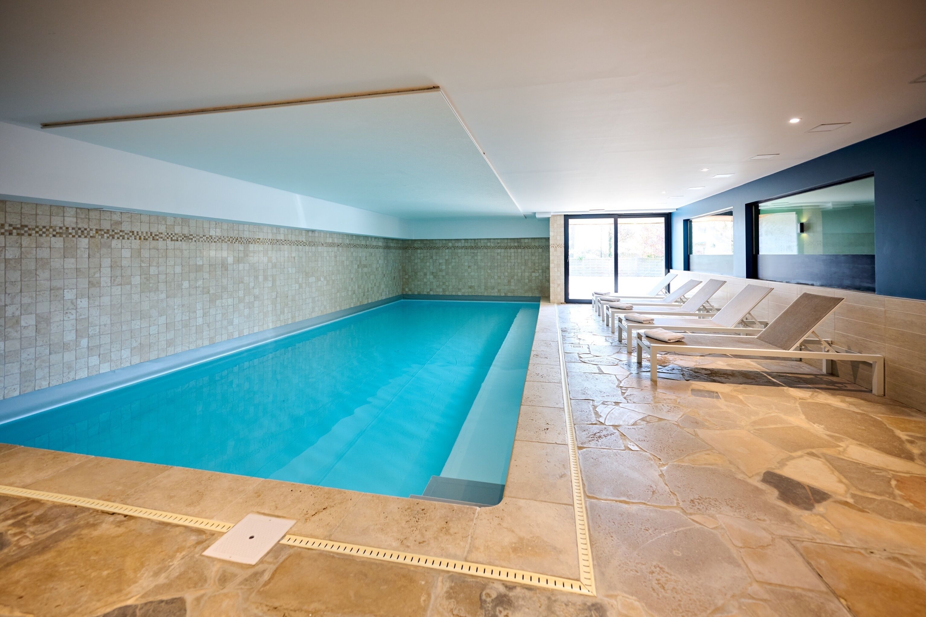 Een binnenzwembad en ligstoelen