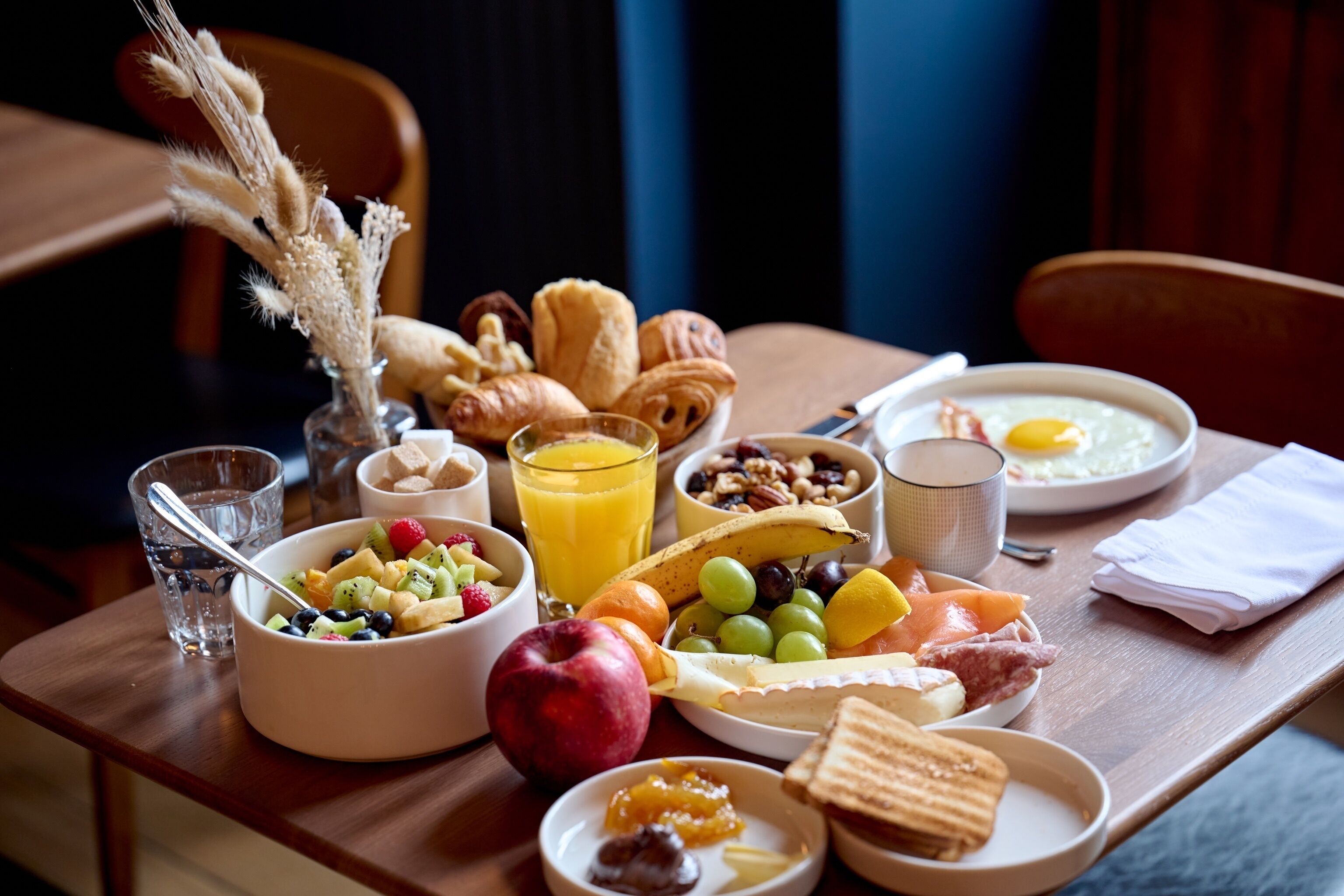Bandeja de desayuno con diversos alimentos, como frutas, pan y huevos.