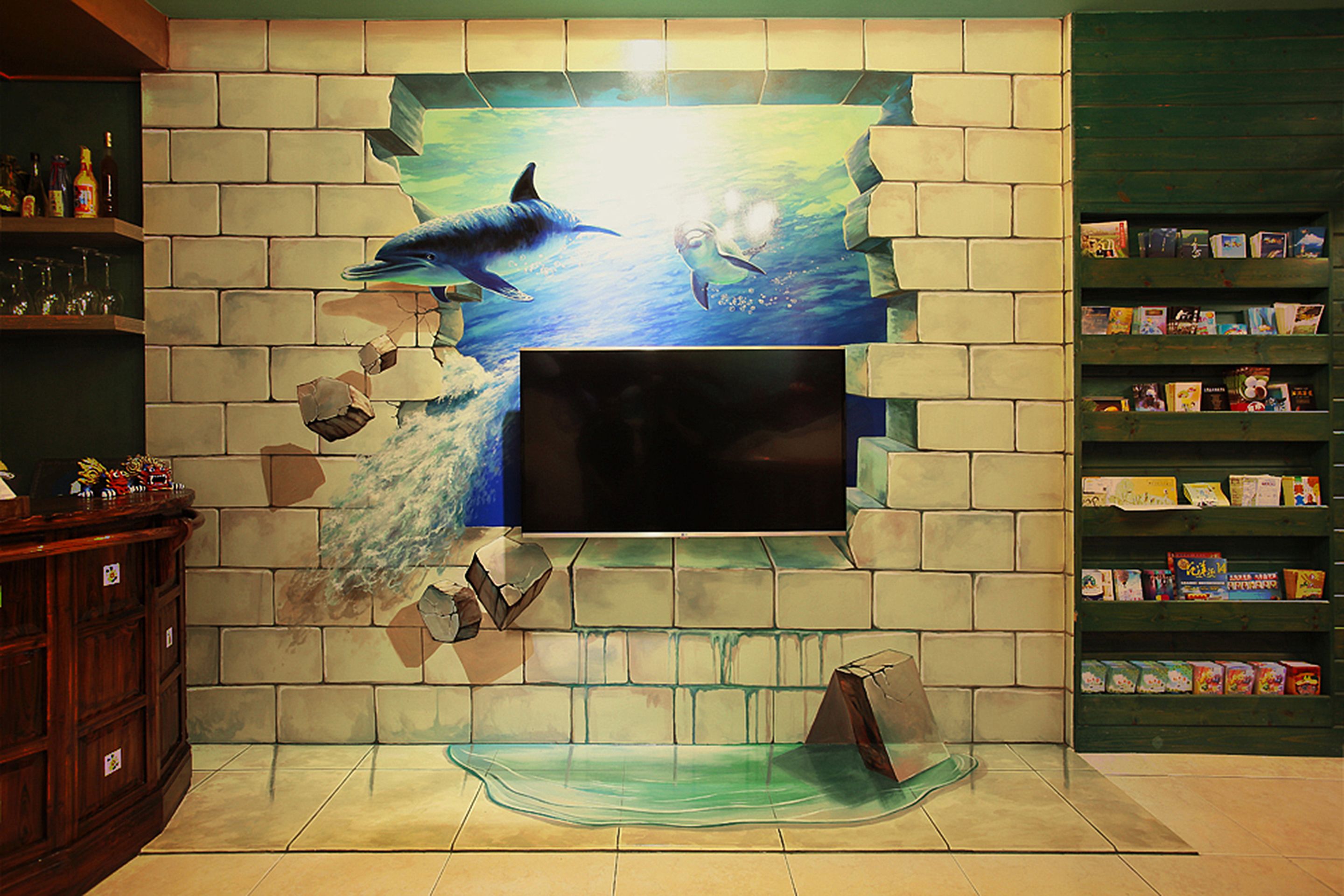 A wall with a TV screen, a shelf with books, and a wooden cabinet.