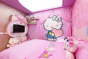 A pink-themed room with a large Hello Kitty wall decal, a round TV stand, and a bed with Hello Kitty bedding. - 3D Sunflower Embossed B&B (Hualien City)