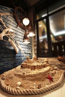 A sandcastle display with a rope border, starfish, and nautical decorations.
