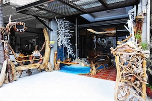 A rustic wooden entrance with a swing, a blue mat, and a welcome sign.