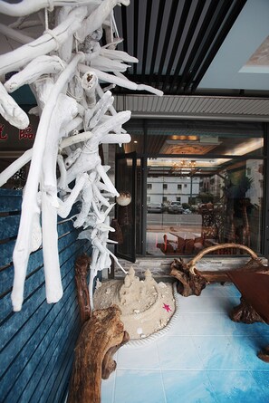 A room with a blue wall, a wooden floor, and a large white sculpture.