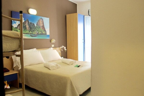 Una habitación de hotel con una cama, una mesita de noche, un cuadro y un armario.