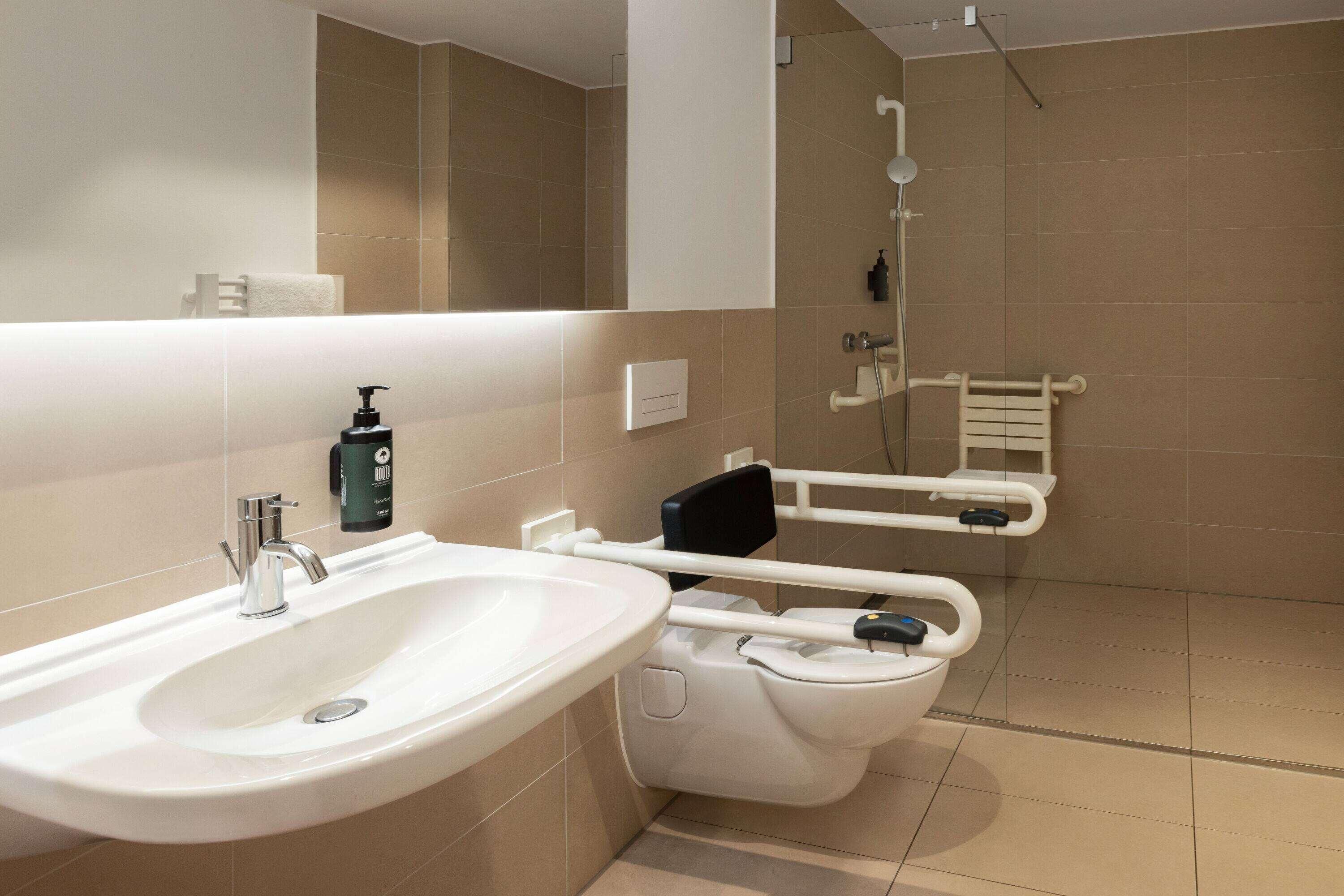 A modern bathroom with a sink, toilet, and shower.