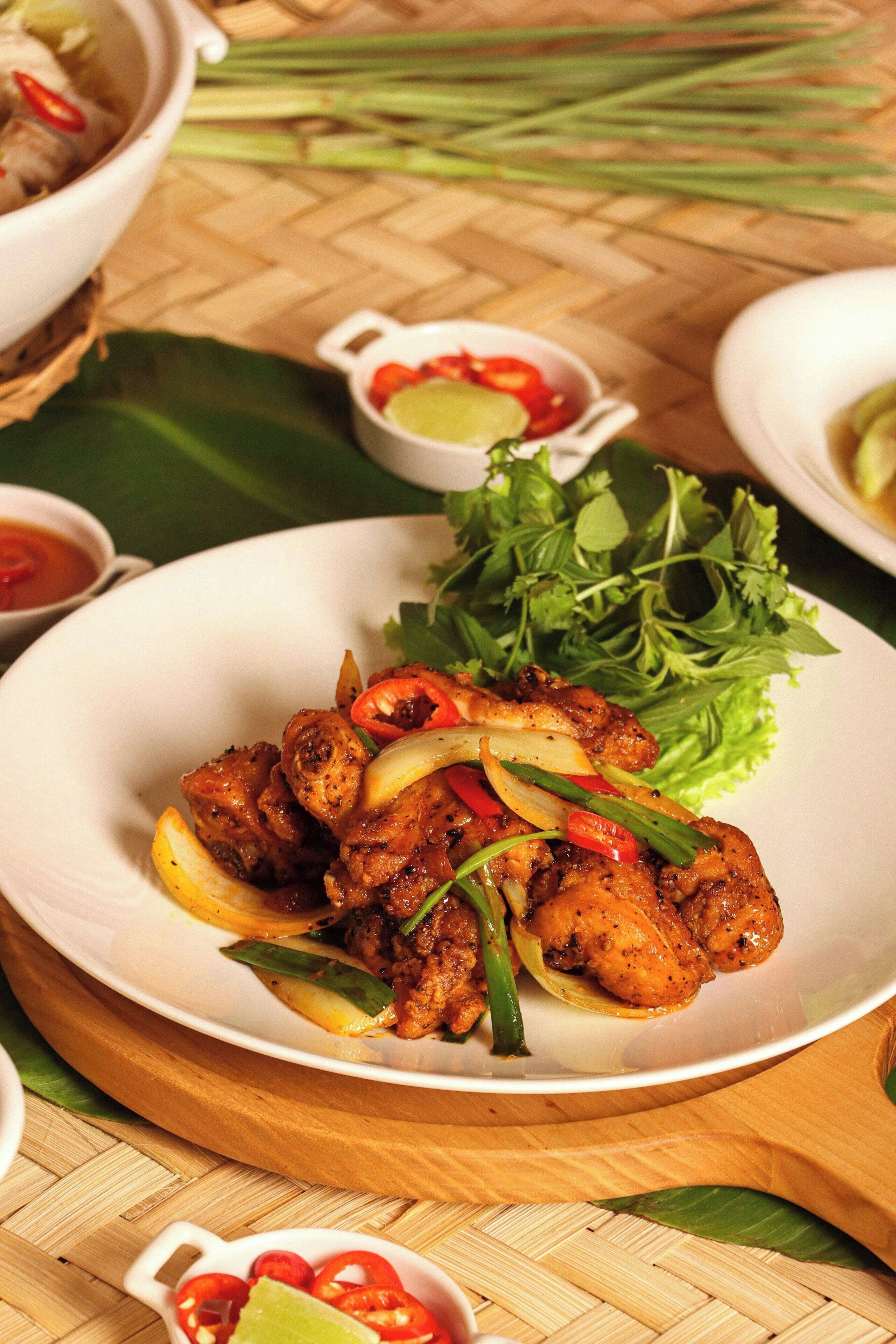 A plate of grilled chicken with vegetables and a side of fresh greens.