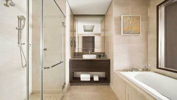 A modern bathroom with a glass-enclosed shower, a large bathtub, and a marble vanity.