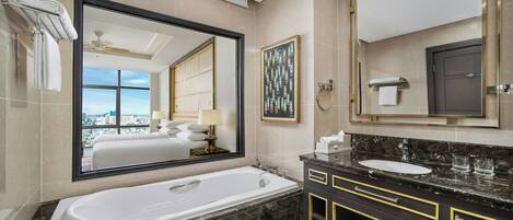 A modern bathroom with a large bathtub, a double sink vanity, and a large mirror.