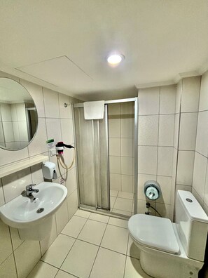 A bathroom with a sink, toilet, and shower area. - Gold Hotel (Istanbul)