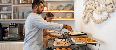 Un buffet proposant divers plats et une machine à café en arrière-plan.