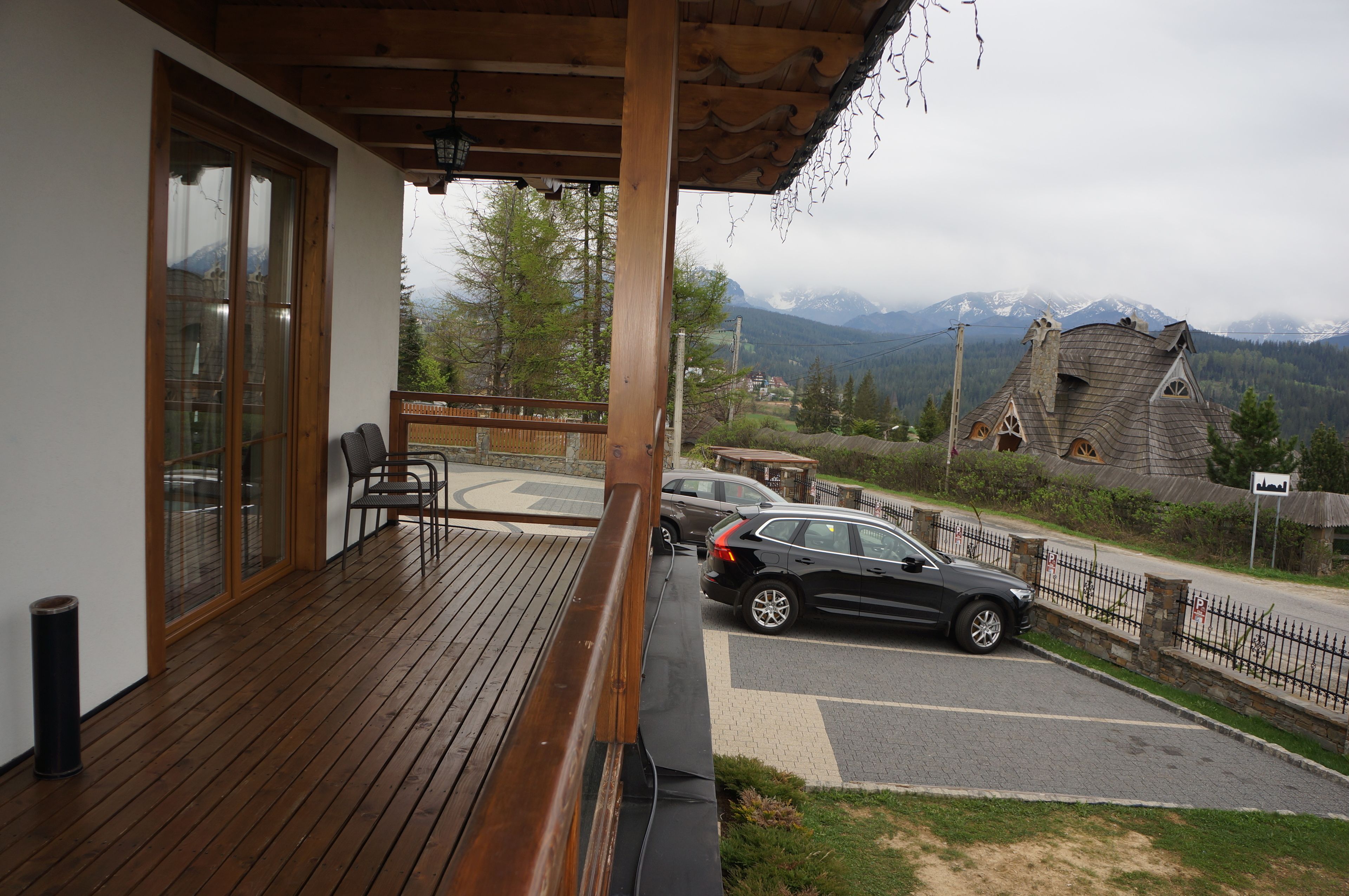 Una terraza de madera con vista a una montaña y un edificio tradicional.
