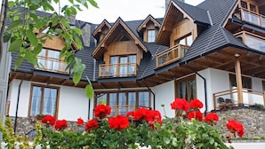 Un bâtiment de style chalet, doté de nombreux balcons en bois et de grandes fenêtres.