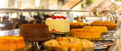 A buffet with various desserts displayed on glass stands.