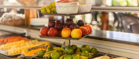 Un bufé con diversas frutas y quesos.