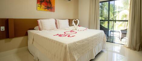 Un dormitorio con cama, un cuadro en la pared y vistas al exterior.