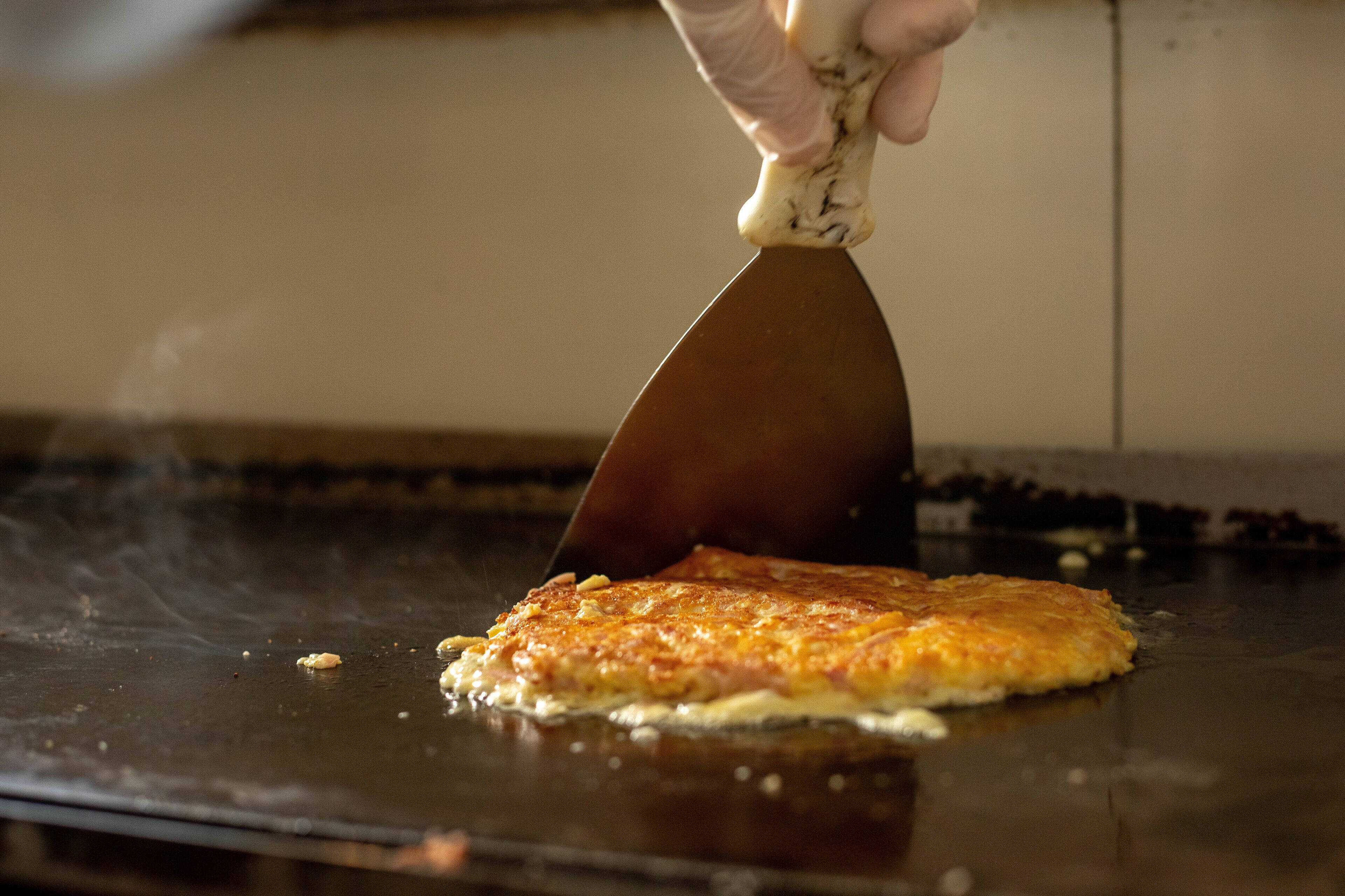 Una persona cocinando un plato en una plancha.